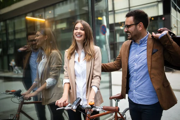 Mutlu iş arkadaşları konuşuyor, gülümsüyor ve şehirde yürüyor.