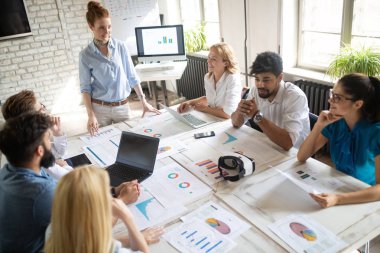 Girişim ekibi, modern ofis içi beyin fırtınası ve çalışan bilgisayar konularında görüştü