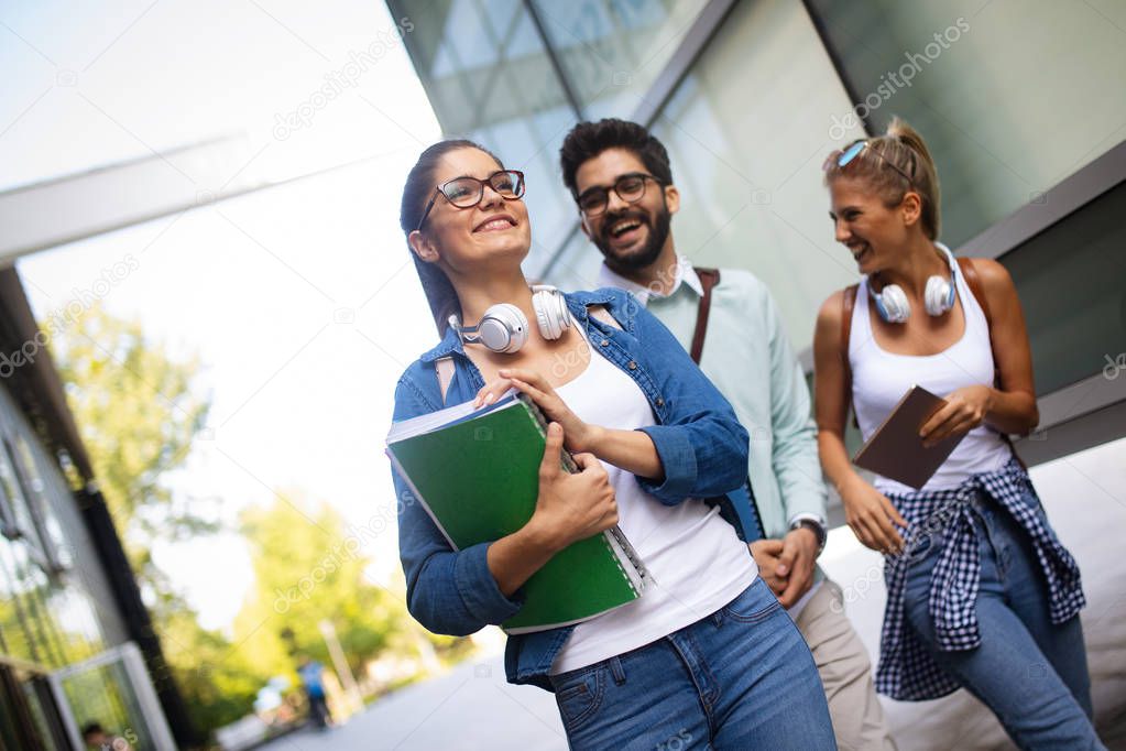 Happy young university friends studying together in college