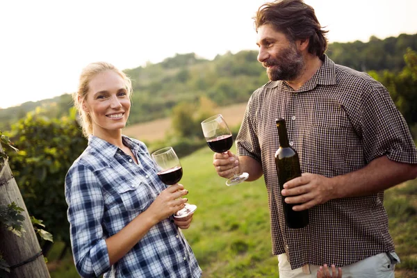 Wine grower family tasting wine in winery vineyard