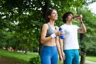Atletik mutlu çift arkadaş içme suyu çalıştırdıktan sonra