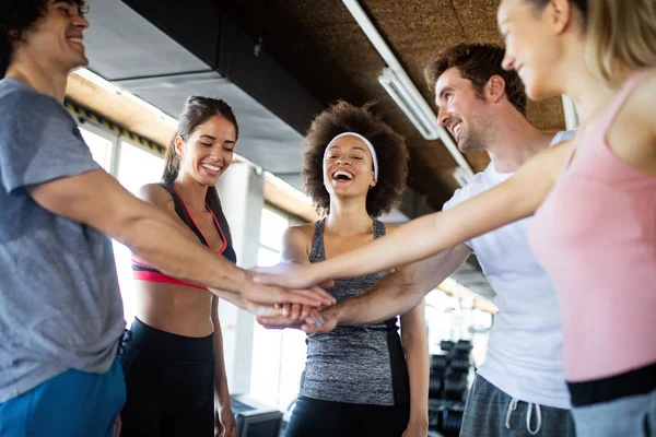 Picture of cheerful young fitness team in gym