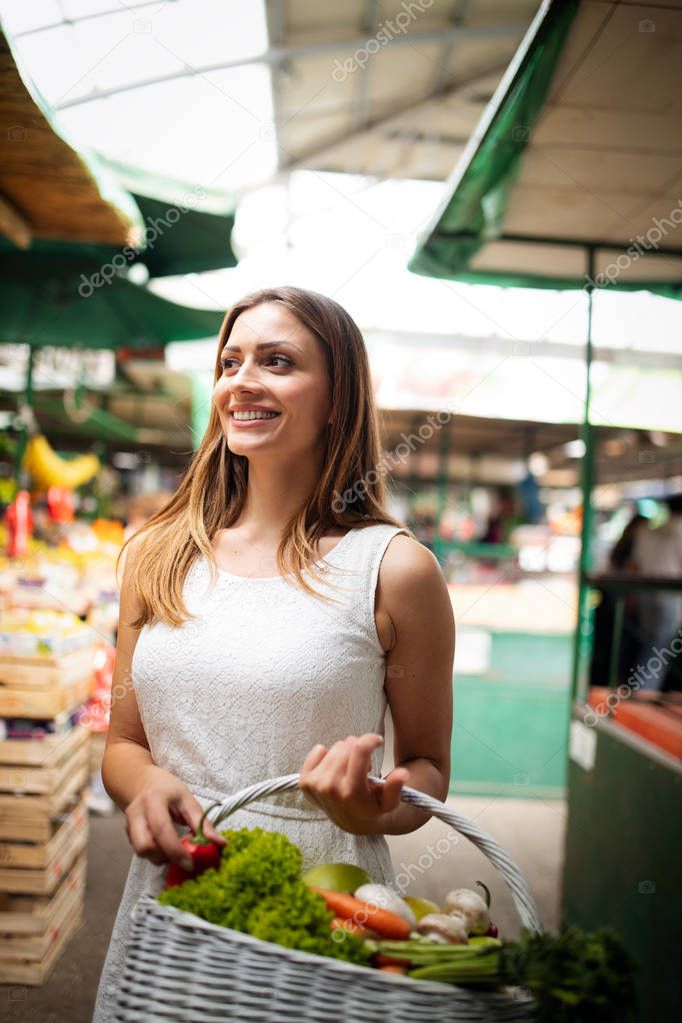 Young happy woman shopping healthy food on the market