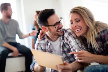 Dijital tablet oynayan ve bakan genç mutlu arkadaşlar