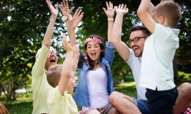 Mutlu çoklu nesil aile parkta piknik yapıyor.