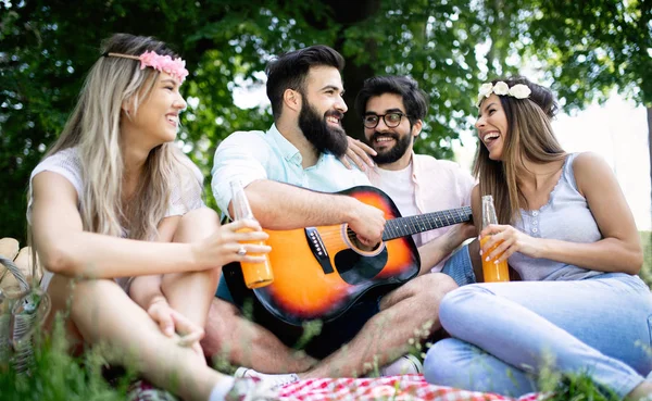 Summer, vacation, music and recreation time concept. Cheerful friends have picnic outdoor.