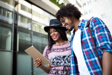 Yaz tatilleri, flört ve turizm konsepti - şehirde tablet ile gülümseyen çift