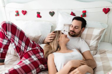 Genç mutlu çift yatak odasında romantik vakit geçiriyor