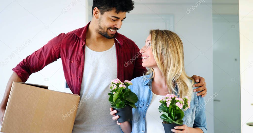 Young happy couple in love moving in new home and unpacking boxes