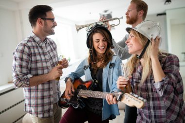 Birlikte eğlenen ve müzik grubunda çalan mutlu gençlerden oluşan bir grup