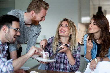 Bir grup mutlu arkadaş evde doğum günü kutluyor.