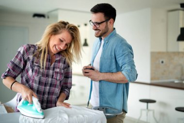 Sevimli çift birlikte oturma odasında ütü