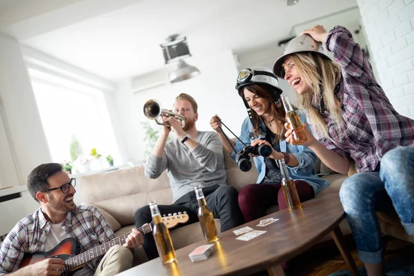 Friends at home enjoying singing and playing guitar, having fun