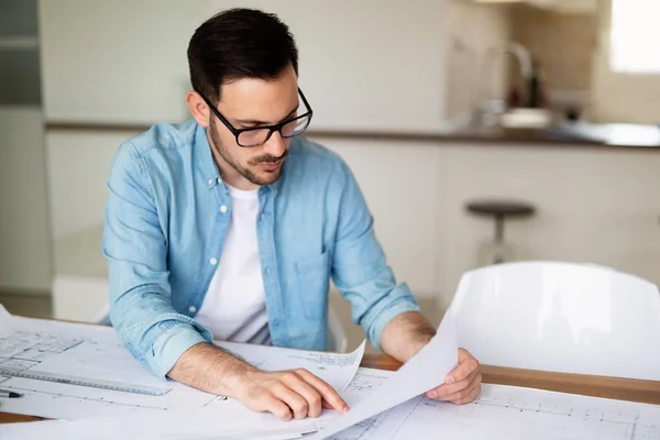 Young architect working on drawing table in office