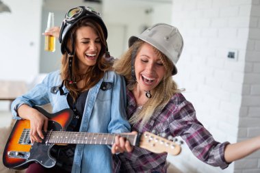 Arkadaşlar evde şarkı söyleme ve gitar çalmanın, eğlenin