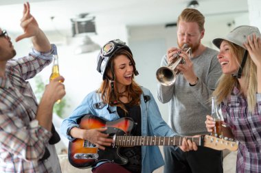 Arkadaşlar evde şarkı söyleme ve gitar çalmanın, eğlenin