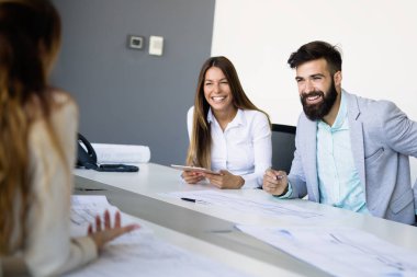 Bir grup mimar ve iş adamı birlikte çalışıyor ve beyin fırtınası yapıyorlar.