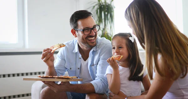 Happy smiling family sharing pizza together at home