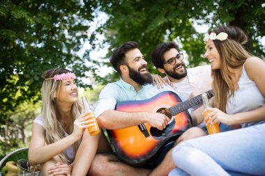 Yaz, tatil, müzik ve eğlence zaman kavramı. Neşeli arkadaşlar açık piknik var.