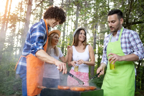 Friends having a barbecue party in nature while having fun