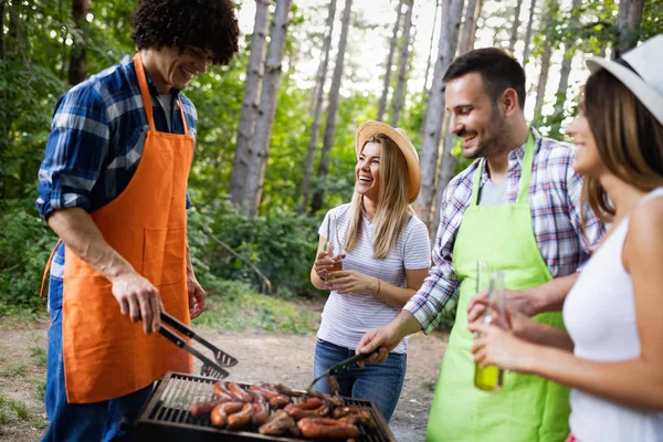 Friends having a barbecue party in nature while having fun