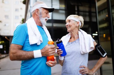 Şehirde koşan olgun bir çift dışarıda koşuyor. Koşucular dışarıda antrenman yapıyor.
