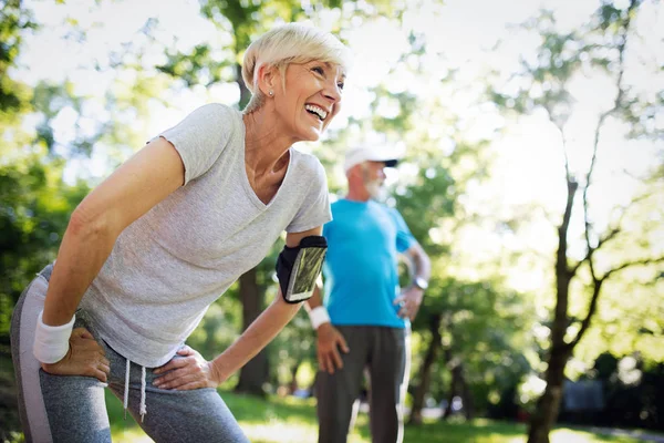 Beautiful senior couple jogging in nature living healthy