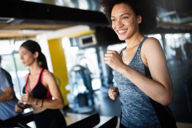 Modern spor salonunda eğitim gören bir grup insan.