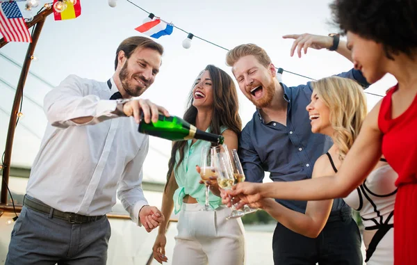 Group of happy people or friends having fun at party and smiling