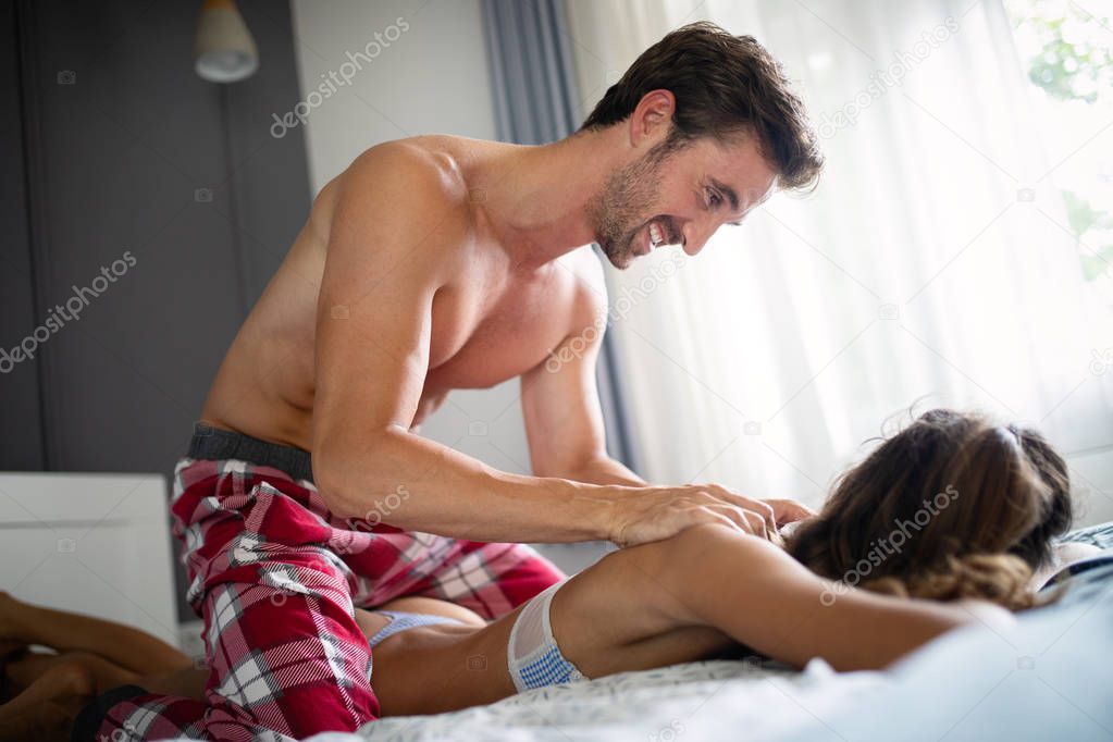 Couple and lovely moments in the bed - Close up of boyfriend giving massage for his beautiful girlfriend relaxing in a bed