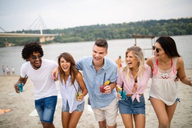 Plajda eğleniyor genç arkadaşlar grubu. Yaz, tatiller, tatil konsepti.