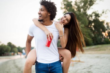 Tatil, tatil, aşk ve dostluk kavramı. Sahilde eğlenen gülümseyen mutlu çift