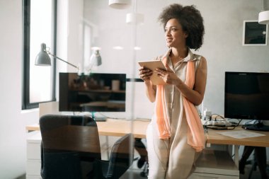 Ofiste tabletle çalışan genç siyahi kadın.