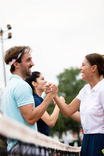 Group of happy tennis player handshaking after playing a tennis match. Respect, fairplay, sport concept.
