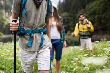 Gün batımında bir dağa yürüyen yürüyüşçüler ve arkadaşlar grubu