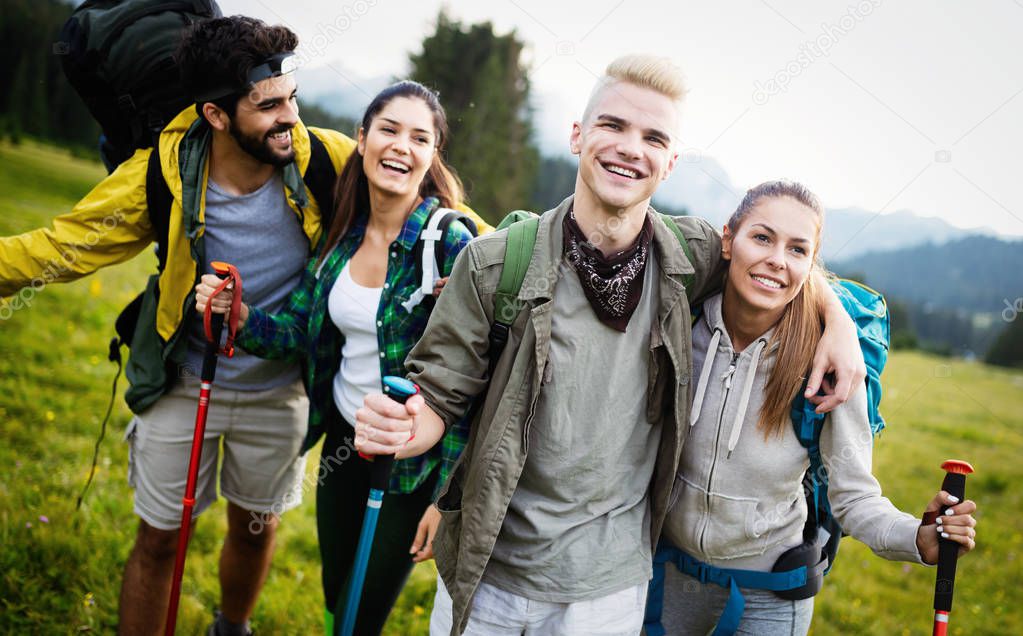 Four happy friends are looking on mountains and having fun