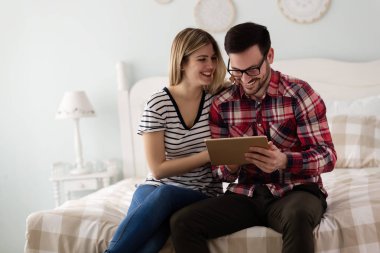 Genç çekici çift yatak odasında dijital tablet kullanma