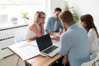 Yaratıcı ofiste çalışan ve iletişim kuran bir grup genç iş adamı.