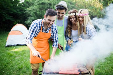 Arkadaşlar doğada bbq yaparak eğleniyorlar.