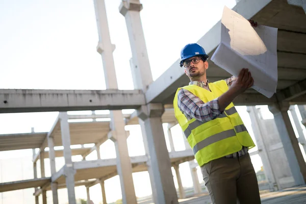 Construction foreman on the job site with blueprint