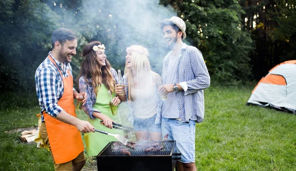 Group of friends having barbecue party in forest