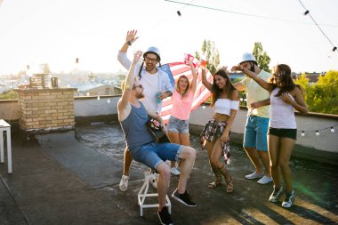 Çatıda parti ve eğlence olan mutlu arkadaşlar grubu