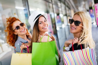 Alışveriş merkezinde alışveriş yaparken alışveriş yaparken alışveriş poşetleri ile kadın arkadaşlar, mağazalar