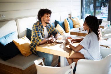 Kafede iki kişi birbirleri ile vakit geçirmekten zevk alıyor, mutlu şık arkadaşlar birlikte kahve içiyor