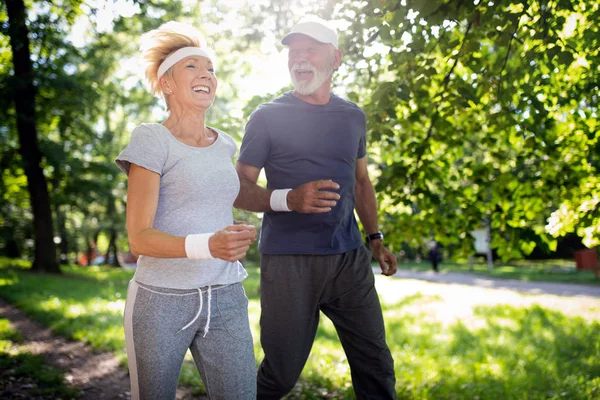 健康的な生活のために公園で走っているアクティブなシニアカップル — ストック写真