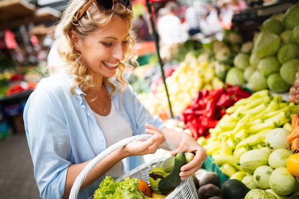 Young happy woman shopping healthy food on the market