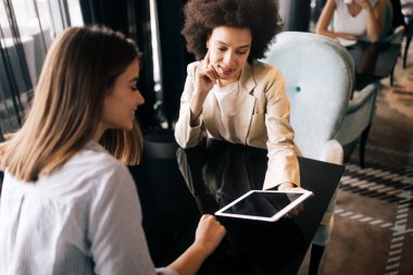 Mutlu kızlar kahve içip, kafede yeni yaratıcı projeleri tartışıyorlar.