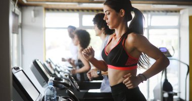 Sağlık kulübünde koşu bandında koşan sağlıklı genç insanlar..