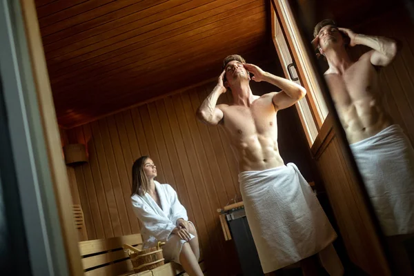 Couple enjoying finnish sauna during their spa weekend — Stock Photo, Image