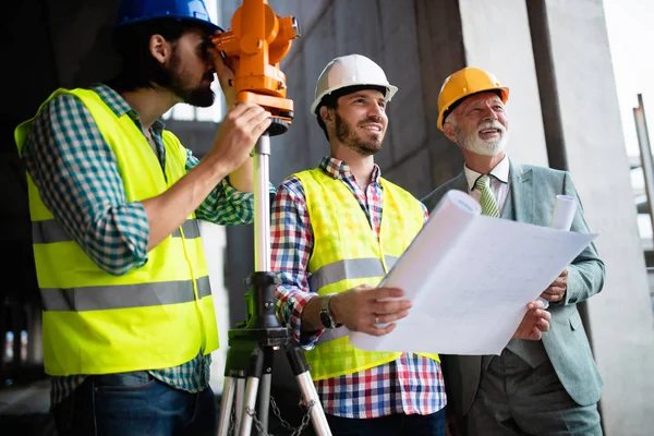 Tryggt team av arkitekter och ingenjörer som arbetar tillsammans på byggarbetsplatsen — Stockfoto